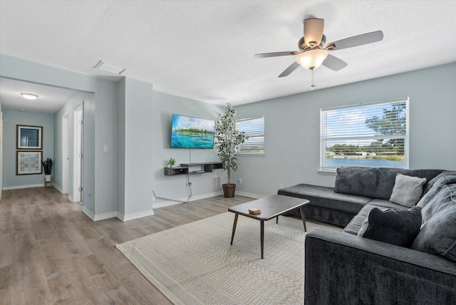 4708 26th Ave W, Bradenton, FL 34209 - living area featuring wood finished floors, ceiling fan, baseboards, and a textured ceiling