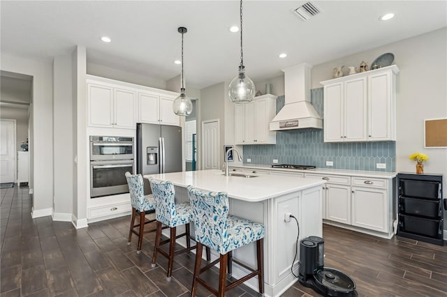 13708 Old Creek Ct, Parrish, FL 34219 - kitchen with a sink, custom exhaust hood, tasteful backsplash, wood tiled floors, and a kitchen breakfast bar