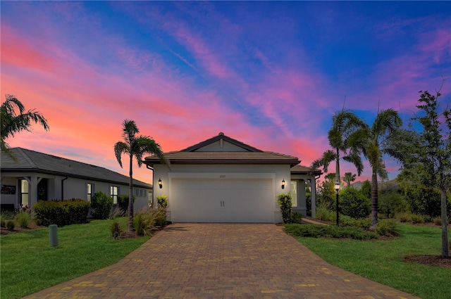 17725 Northwood Pl, Bradenton, FL 34202 - ranch-style house with decorative driveway, a yard, a garage, and stucco siding