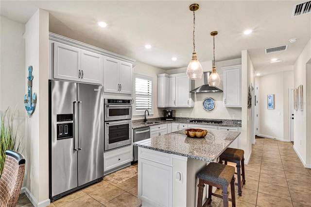 17725 Northwood Pl, Bradenton, FL 34202 - kitchen featuring appliances with stainless steel finishes, a sink, wall chimney range hood, a center island, and light tile patterned floors
