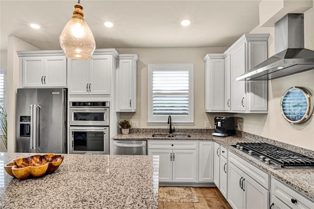 17725 Northwood Pl, Bradenton, FL 34202 - kitchen featuring a sink, appliances with stainless steel finishes, wall chimney range hood, white cabinetry, and light stone countertops