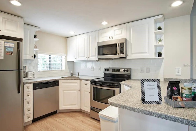 6157 Midnight Pass Rd Unit E73, Sarasota, FL 34242 - kitchen with appliances with stainless steel finishes, open shelves, a sink, white cabinetry, and light wood-type flooring