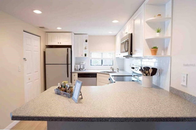 6157 Midnight Pass Rd Unit E73, Sarasota, FL 34242 - kitchen featuring open shelves, stainless steel appliances, a sink, white cabinets, and a peninsula