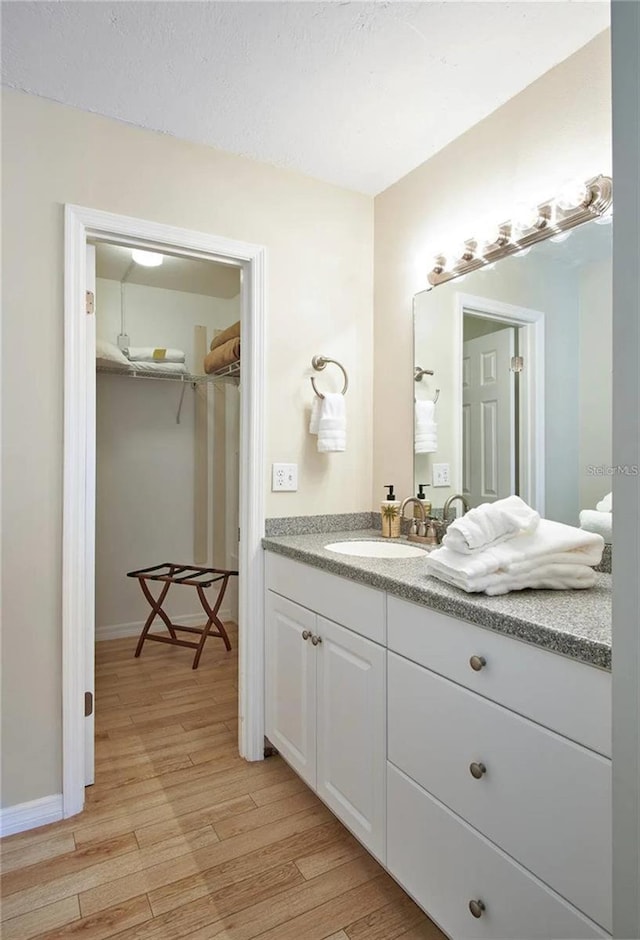 6157 Midnight Pass Rd Unit E73, Sarasota, FL 34242 - bathroom with wood finished floors, vanity, a spacious closet, and baseboards