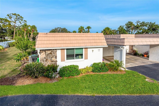 2419 Riverbluff Pkwy Unit V233, Sarasota, FL 34231 - view of front of home with driveway, a carport, stone siding, stucco siding, and mansard roof