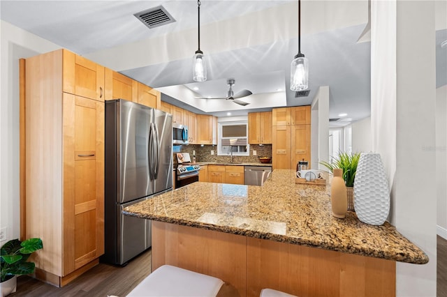 2419 Riverbluff Pkwy Unit V233, Sarasota, FL 34231 - kitchen featuring stainless steel appliances, dark wood finished floors, light stone counters, a tray ceiling, and tasteful backsplash
