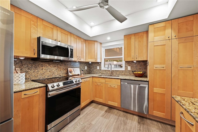 2419 Riverbluff Pkwy Unit V233, Sarasota, FL 34231 - kitchen featuring appliances with stainless steel finishes, a sink, light wood finished floors, ceiling fan, and backsplash