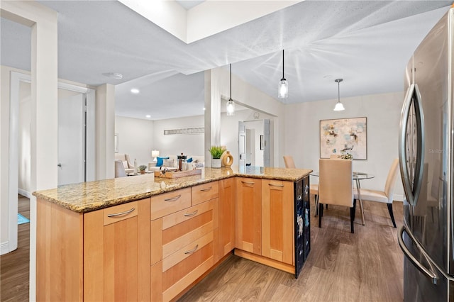 2419 Riverbluff Pkwy Unit V233, Sarasota, FL 34231 - kitchen with freestanding refrigerator, light brown cabinets, light wood finished floors, light stone countertops, and recessed lighting