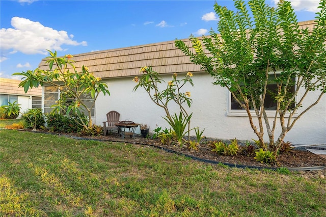 2419 Riverbluff Pkwy Unit V233, Sarasota, FL 34231 - view of side of property with stucco siding, a lawn, and mansard roof