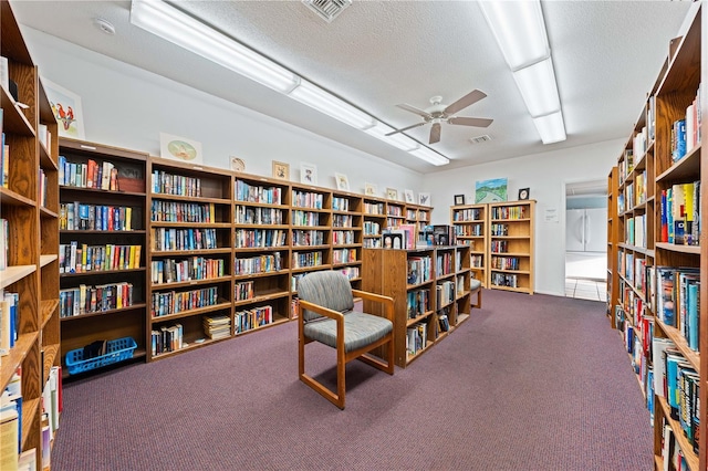 2419 Riverbluff Pkwy Unit V233, Sarasota, FL 34231 - living area featuring bookshelves, carpet, a textured ceiling, and ceiling fan