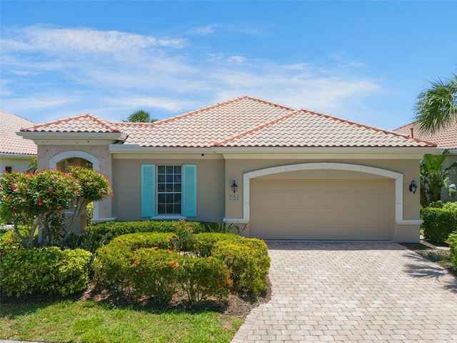 7164 Rue De Palisades Unit 5, Sarasota, FL 34238 - mediterranean / spanish home featuring stucco siding, a garage, decorative driveway, and a tiled roof