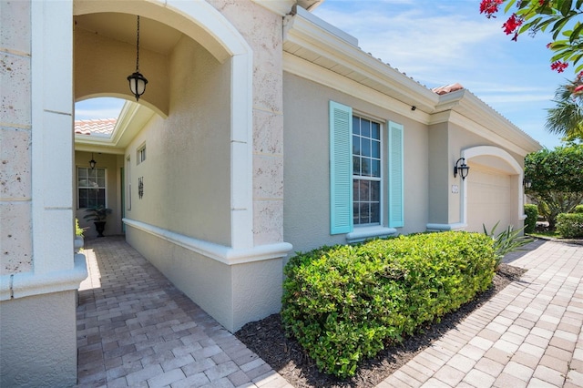 7164 Rue De Palisades Unit 5, Sarasota, FL 34238 - view of exterior entry featuring an attached garage and stucco siding