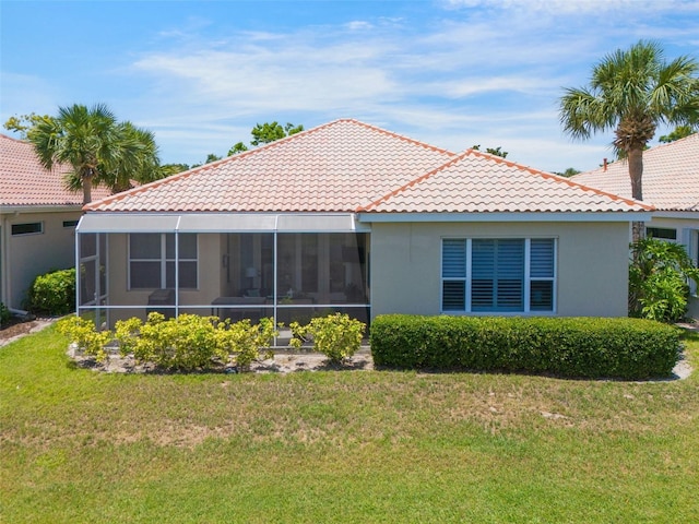 7164 Rue De Palisades Unit 5, Sarasota, FL 34238 - back of property featuring a tiled roof, a lawn, a sunroom, and stucco siding