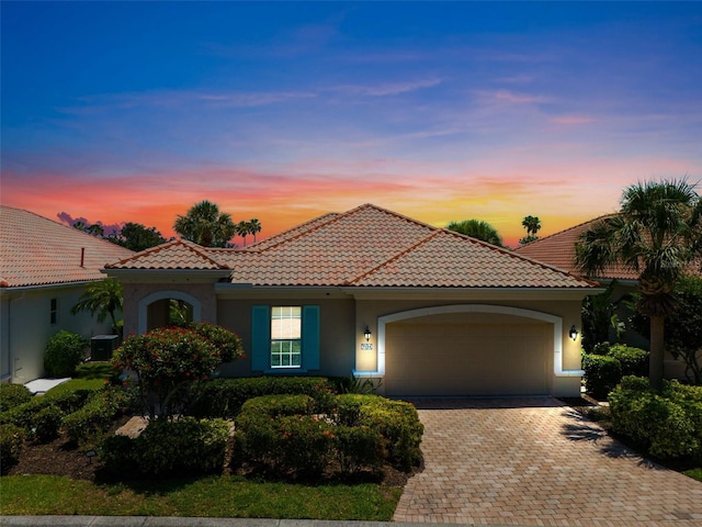 7164 Rue De Palisades Unit 5, Sarasota, FL 34238 - mediterranean / spanish house featuring stucco siding, an attached garage, decorative driveway, a tile roof, and cooling unit