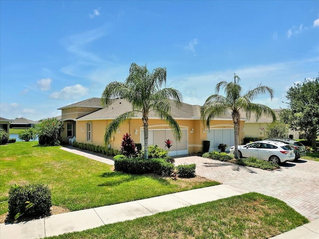 635 Chipper Dr, Sun City Center, FL 33573 - view of front facade with decorative driveway, a front yard, stucco siding, and a garage