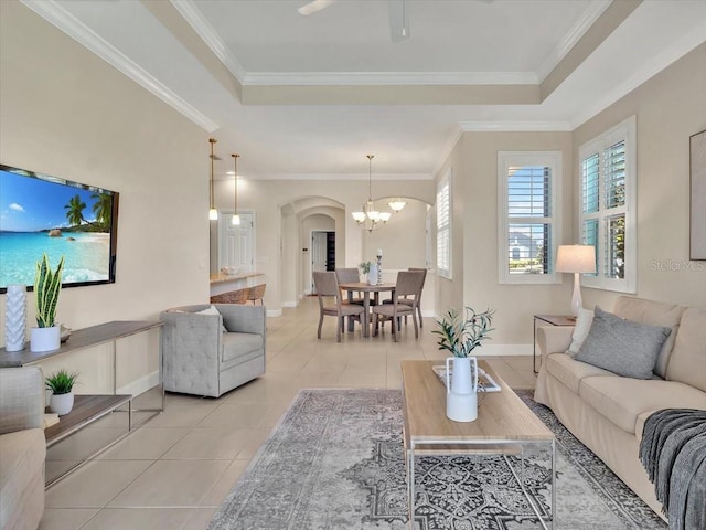 635 Chipper Dr, Sun City Center, FL 33573 - living room featuring light tile patterned flooring, a raised ceiling, arched walkways, a chandelier, and baseboards