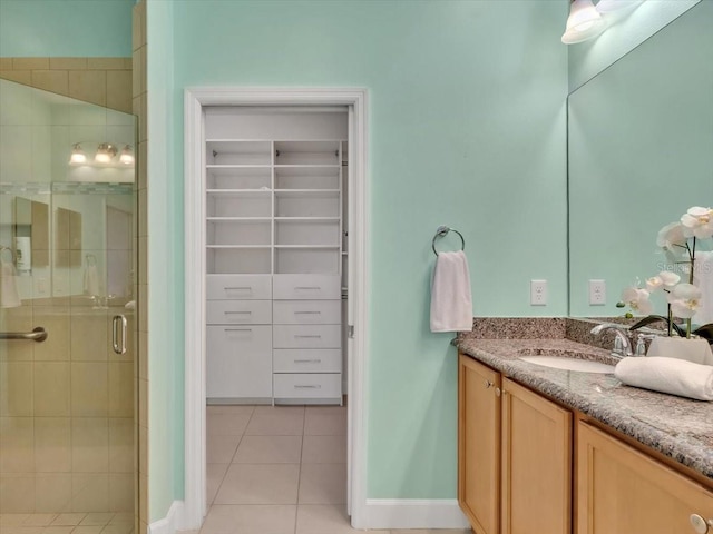635 Chipper Dr, Sun City Center, FL 33573 - full bathroom featuring a shower stall, tile patterned flooring, vanity, a spacious closet, and baseboards