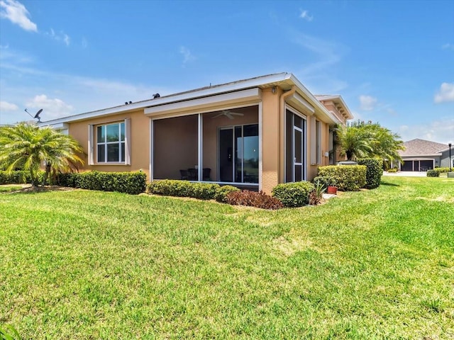 635 Chipper Dr, Sun City Center, FL 33573 - back of house with a lawn, stucco siding, and a sunroom