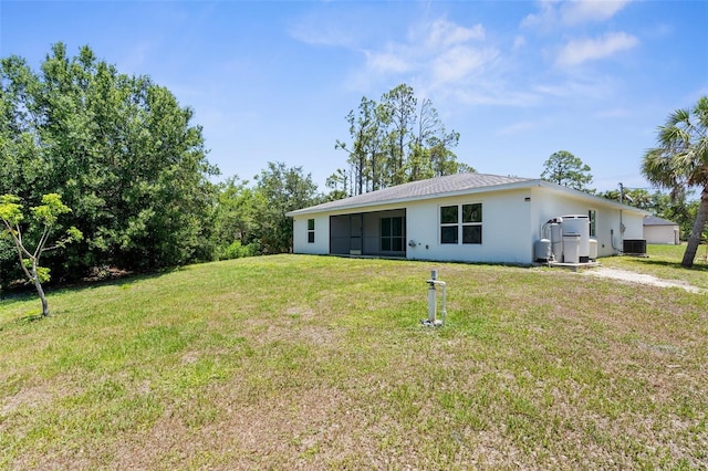 2575 Johannesberg Rd, North Port, FL 34288 - back of property featuring stucco siding, a yard, and central air condition unit
