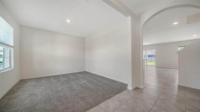 12728 Lateral Root Dr, Sarasota, FL 34238 - carpeted empty room with arched walkways, baseboards, tile patterned flooring, and recessed lighting