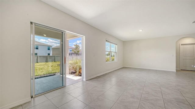 12728 Lateral Root Dr, Sarasota, FL 34238 - spare room with baseboards, arched walkways, and light tile patterned floors