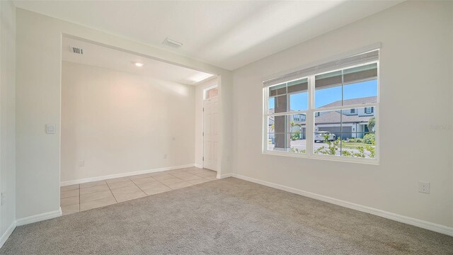 12732 Lateral Root Dr, Sarasota, FL 34238 - spare room featuring light carpet, light tile patterned floors, and baseboards
