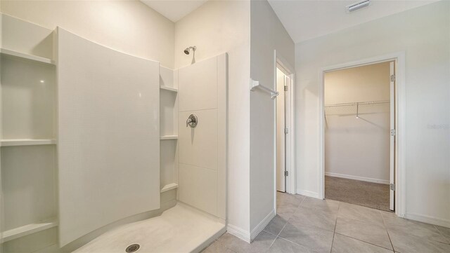 12732 Lateral Root Dr, Sarasota, FL 34238 - bathroom with a stall shower, tile patterned flooring, a spacious closet, and baseboards