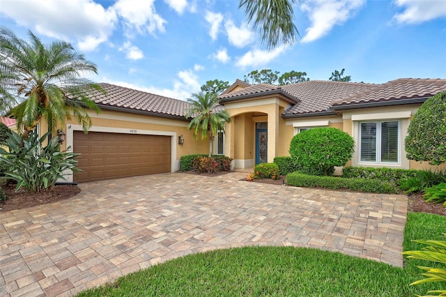 4818 88th St E, Bradenton, FL 34211 - mediterranean / spanish house with a garage, stucco siding, driveway, and a tile roof