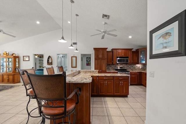 13719 Seminole Trl, Wimauma, FL 33598 - kitchen featuring a ceiling fan, appliances with stainless steel finishes, vaulted ceiling, backsplash, and a breakfast bar area