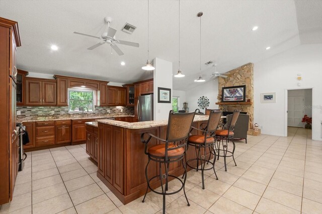 13719 Seminole Trl, Wimauma, FL 33598 - kitchen featuring ceiling fan, decorative backsplash, light stone counters, a large island, and freestanding refrigerator