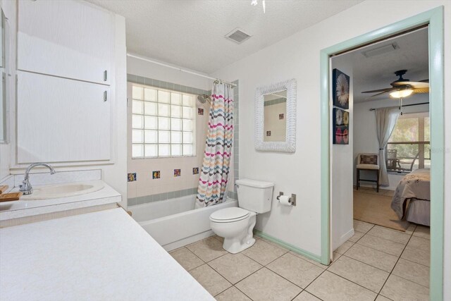 13719 Seminole Trl, Wimauma, FL 33598 - bathroom with tile patterned flooring, a ceiling fan, toilet, connected bathroom, and a textured ceiling