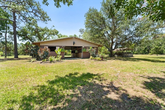 13719 Seminole Trl, Wimauma, FL 33598 - view of grassy yard featuring a carport, an outbuilding, and a pole building