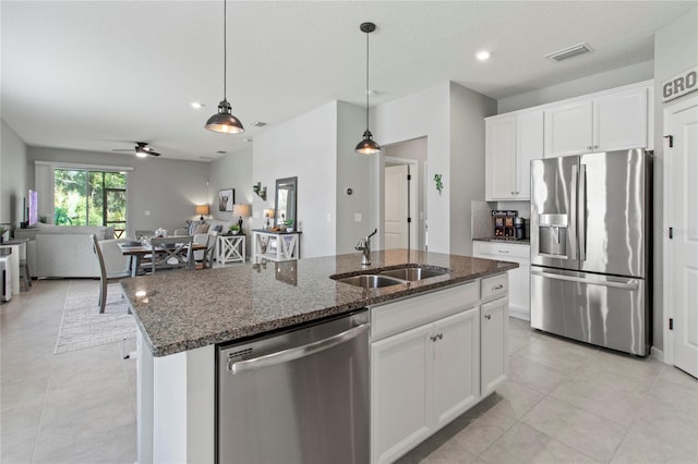 10962 High Noon Trl, Parrish, FL 34219 - kitchen featuring stainless steel appliances, a sink, an island with sink, dark stone counters, and ceiling fan