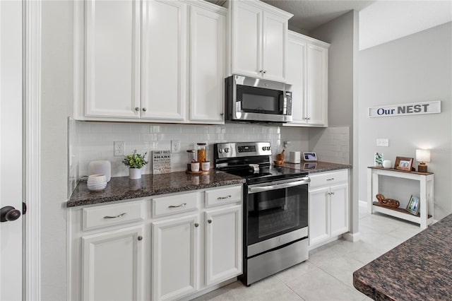 10962 High Noon Trl, Parrish, FL 34219 - kitchen featuring stainless steel appliances, tasteful backsplash, white cabinets, light tile patterned floors, and dark stone countertops
