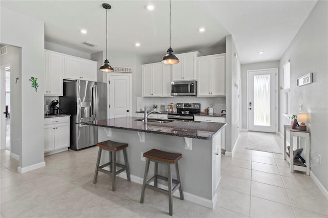 10962 High Noon Trl, Parrish, FL 34219 - kitchen featuring stainless steel appliances, a sink, dark stone counters, recessed lighting, and white cabinets