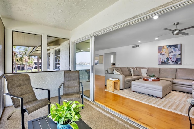 living area featuring a ceiling fan, recessed lighting, a textured ceiling, and carpet flooring