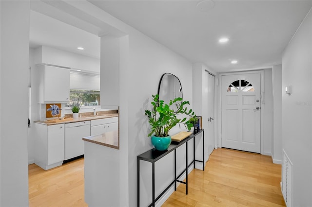 foyer entrance featuring light wood finished floors, recessed lighting, and baseboards
