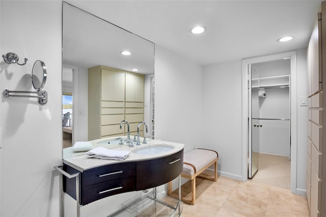 bathroom with recessed lighting, vanity, a spacious closet, and baseboards