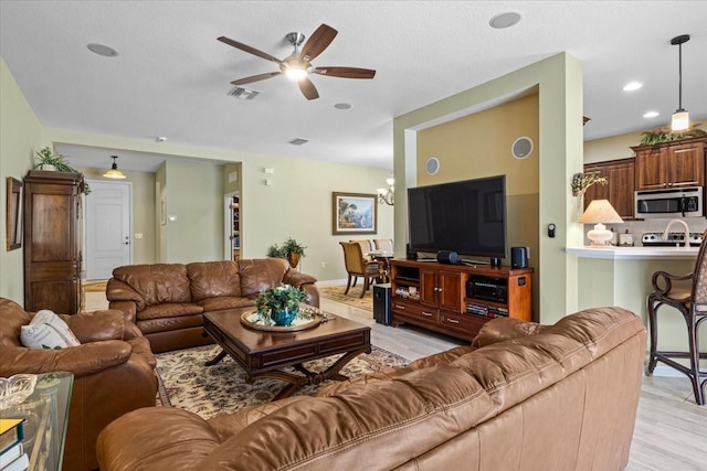4402 Natures Reach Ter, Parrish, FL 34219 - living room featuring a ceiling fan, light wood-type flooring, a chandelier, and baseboards