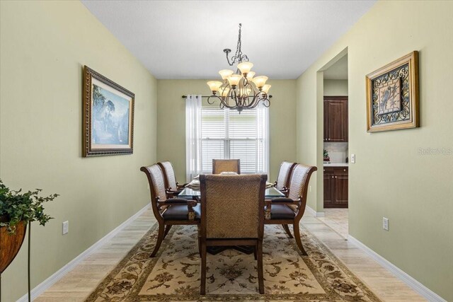 4402 Natures Reach Ter, Parrish, FL 34219 - dining room with a chandelier, light wood-type flooring, and baseboards