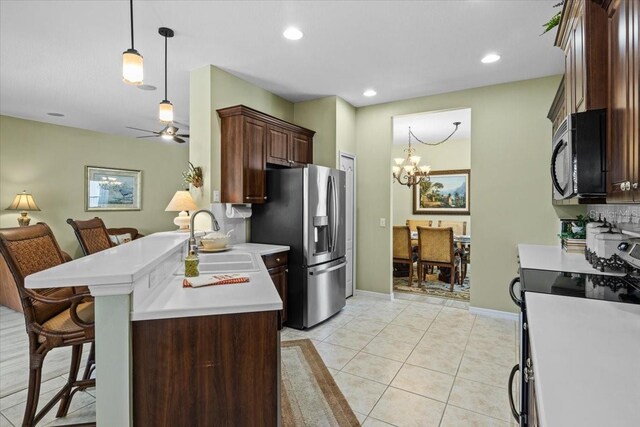 4402 Natures Reach Ter, Parrish, FL 34219 - kitchen featuring a sink, stainless steel appliances, a kitchen breakfast bar, light countertops, and a chandelier