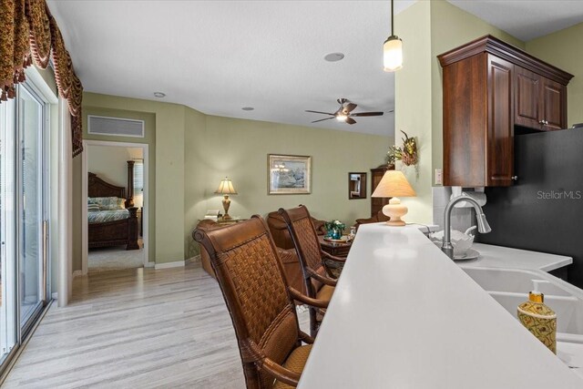 4402 Natures Reach Ter, Parrish, FL 34219 - home office with a ceiling fan, light wood-style flooring, a sink, and baseboards
