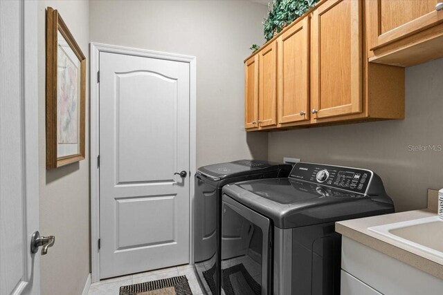 4402 Natures Reach Ter, Parrish, FL 34219 - washroom with cabinet space, washer and clothes dryer, and light tile patterned floors