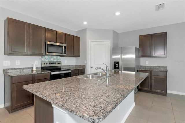 12712 Dusty Trail Dr, Sarasota, FL 34238 - kitchen with stainless steel appliances, a sink, baseboards, light tile patterned floors, and dark brown cabinets