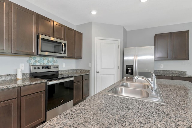 12712 Dusty Trail Dr, Sarasota, FL 34238 - kitchen with stainless steel appliances, a sink, dark brown cabinetry, recessed lighting, and light stone counters