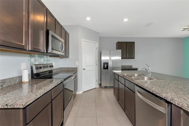 12712 Dusty Trail Dr, Sarasota, FL 34238 - kitchen featuring stainless steel appliances, a sink, dark brown cabinetry, light tile patterned floors, and recessed lighting