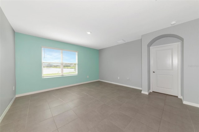 12712 Dusty Trail Dr, Sarasota, FL 34238 - unfurnished room with baseboards, a smoke detector, light tile patterned floors, and arched walkways