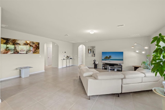 27519 Pasto Dr, Punta Gorda, FL 33983 - living room with arched walkways, light tile patterned flooring, and baseboards