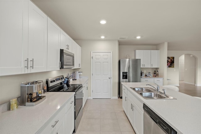 27519 Pasto Dr, Punta Gorda, FL 33983 - kitchen with stainless steel appliances, a sink, arched walkways, light countertops, and white cabinets