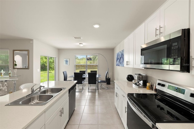 27519 Pasto Dr, Punta Gorda, FL 33983 - kitchen with stainless steel appliances, a sink, light countertops, white cabinets, and recessed lighting